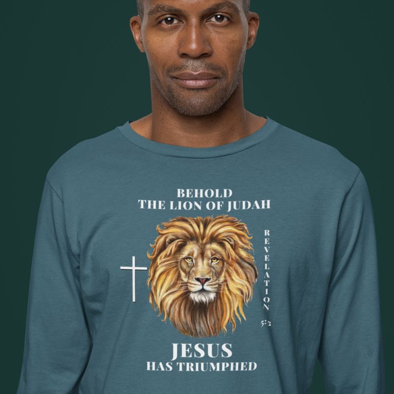 Black man wearing an teal shirt that says "Behold the lion of Judah". Below the text, there is a graphic of a lion, with a cross icon next to it, and "Revelation 5:5". On the bottom, text says "JESUS has triumphed"