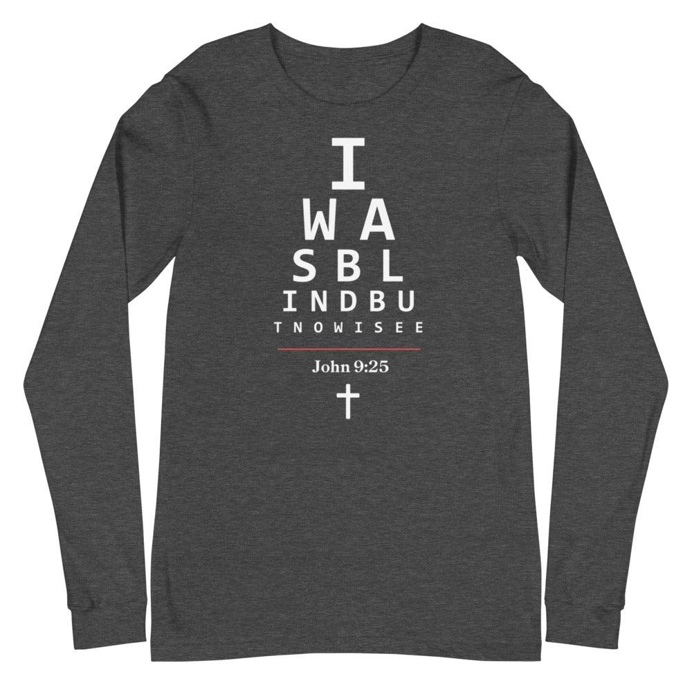 Flatlay of a long-sleeve gray Christian shirt.
The graphic is text as an eye chart, and it says "I WAS BLIND BUT NOW I SEE".
Below the text, there is a thin line, with text "John 9:25" and an icon of a cross below.