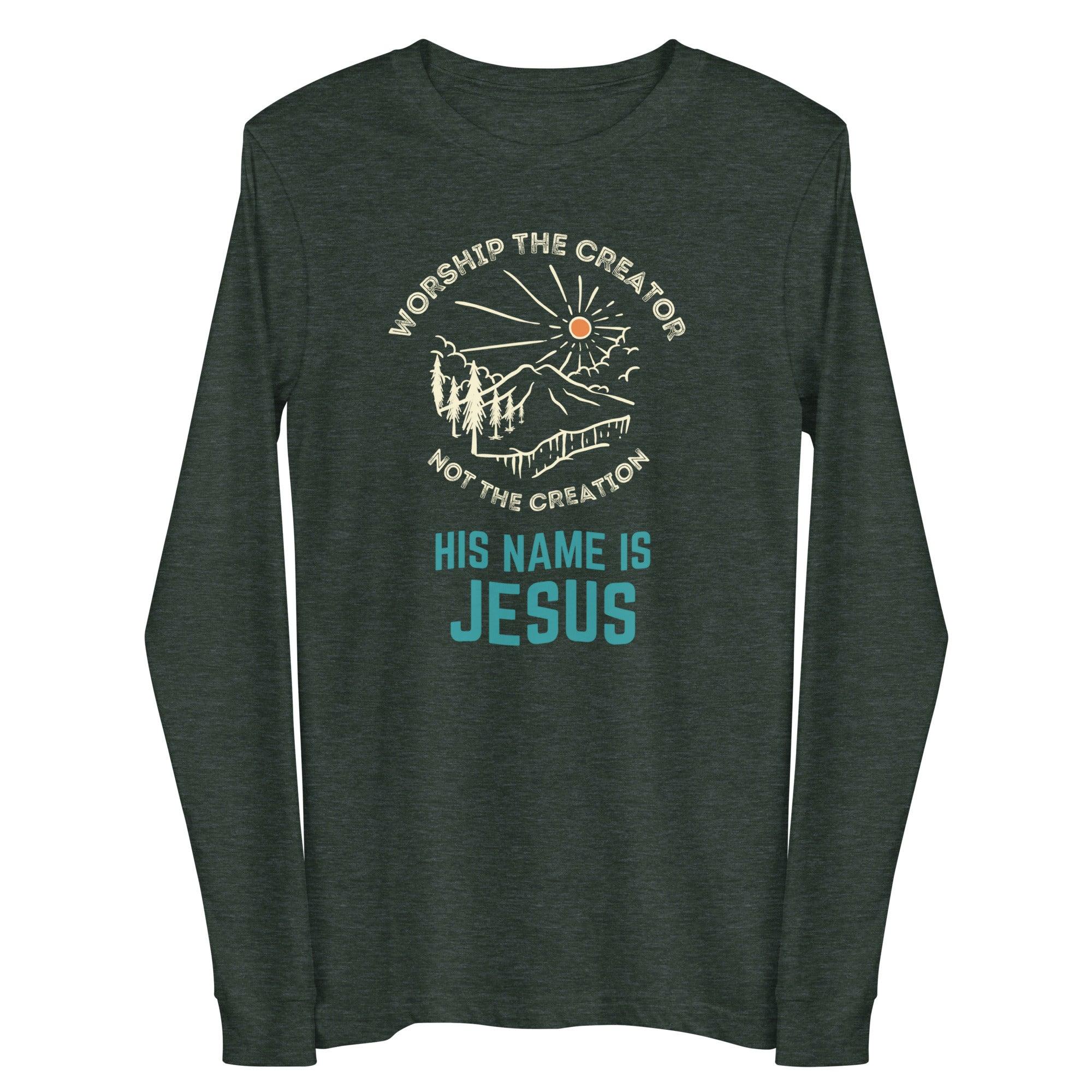 Flatlay of a pine green long sleeve Christian shirt. There is a graphic of a mountain, trees, and sun. Over the graphic, it says "Worship the creator", and under it says "not the creation". On the bottom, it says "His name is Jesus". This shirt is sold at Amela&