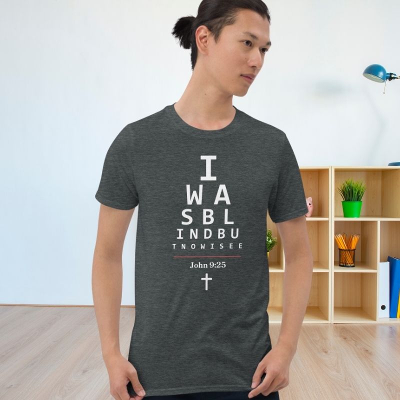 Asian man wearing a gray Christian t-shirt. 

The graphic is text as an eye chart, and it says &quot;I WAS BLIND BUT NOW I SEE&quot;.

Below the text, there is a thin line, with text &quot;John 9:25&quot; and an icon of a cross below.