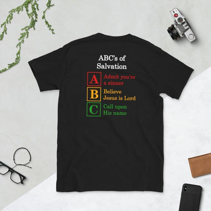 A flatlay photo of a back of a black shirt, showcasing a Christian design, that says:
ABC&